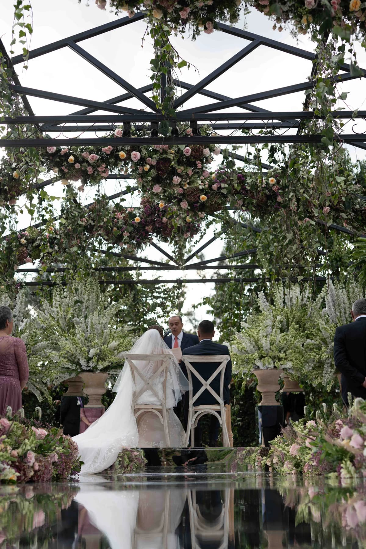 Ceremonia de boda en un jardín vista a través de un espejo
