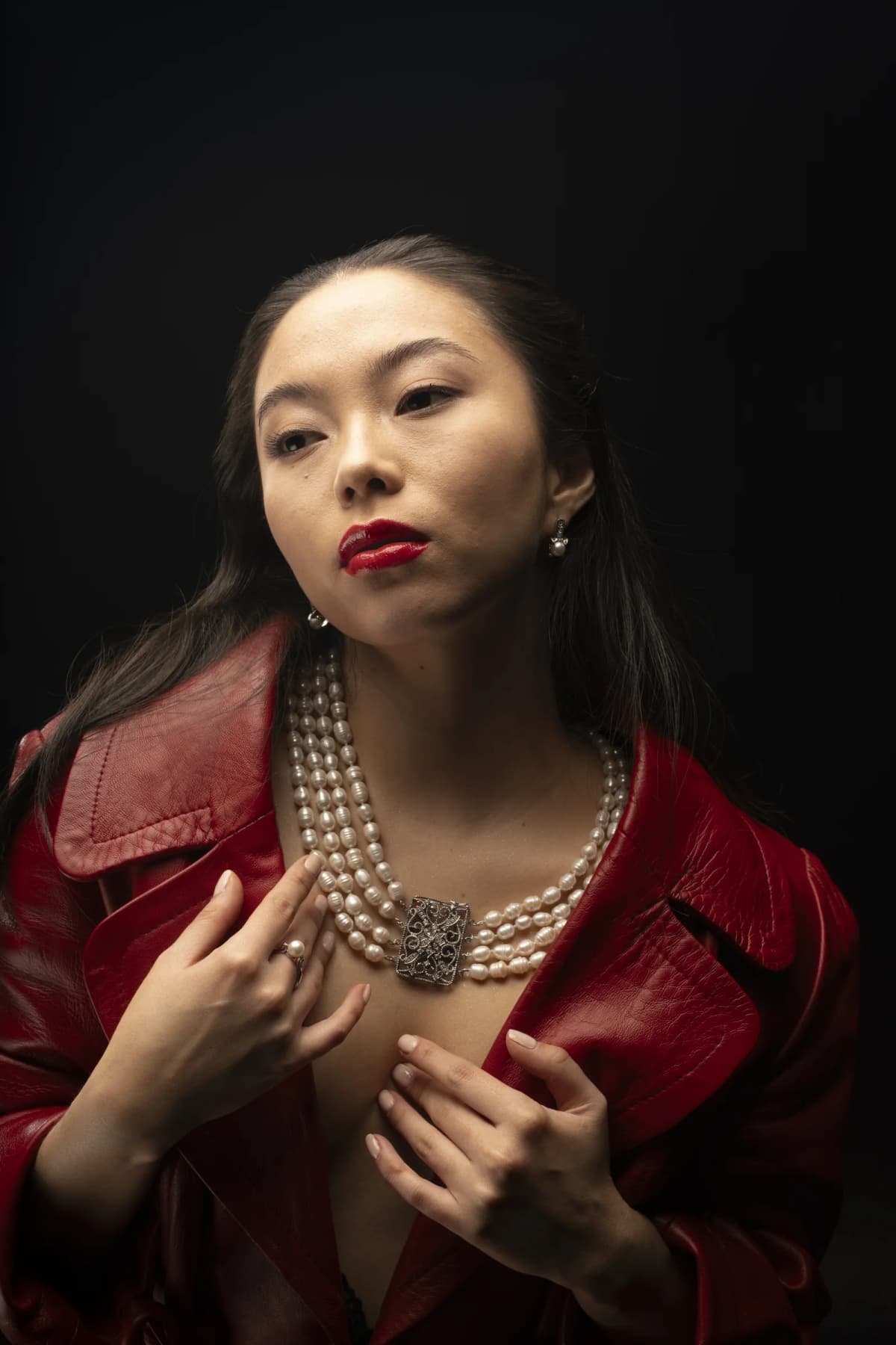 Retrato de belleza con perlas y chaqueta roja