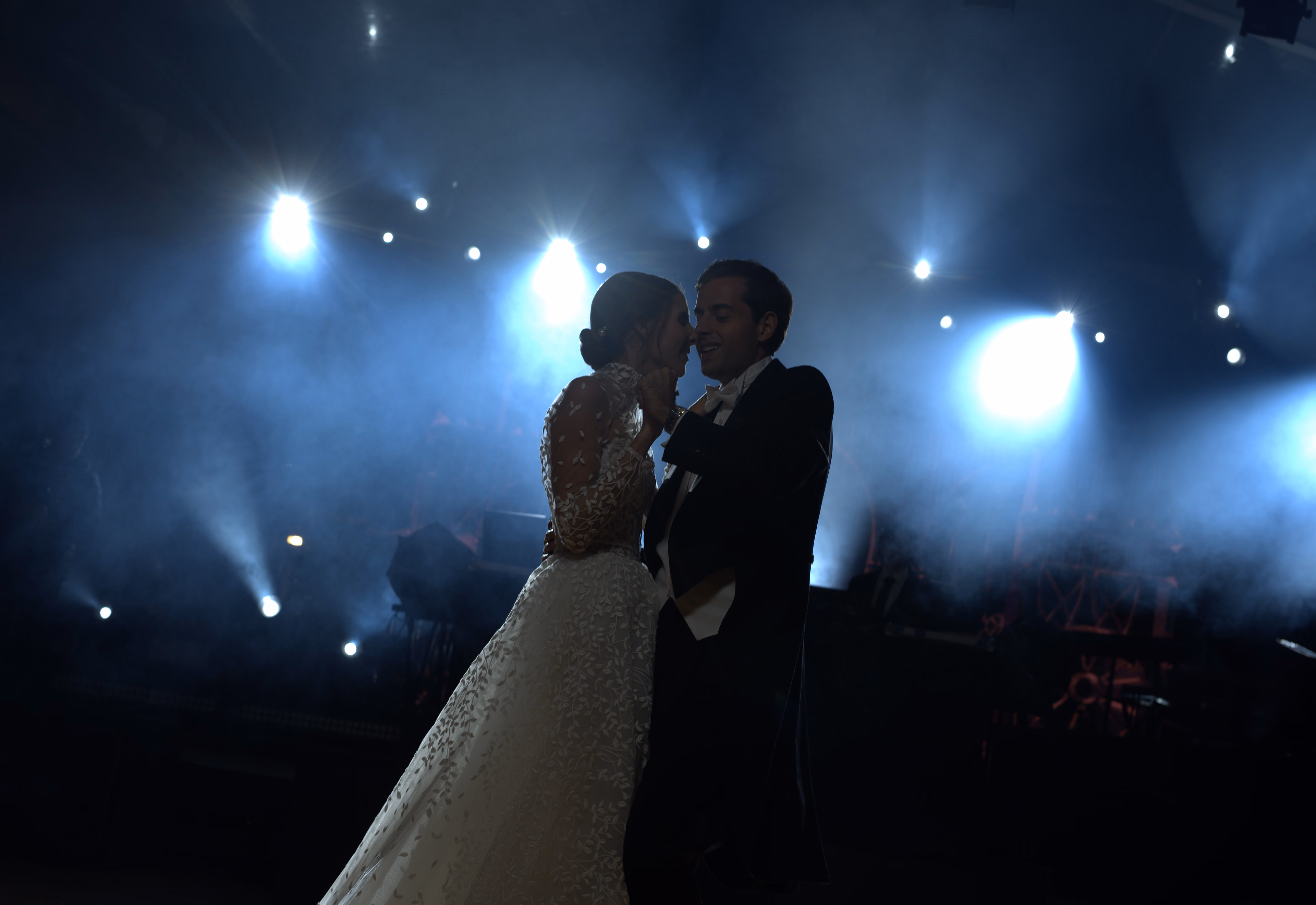 Pareja sonriendo durante su primer baile con luces azules