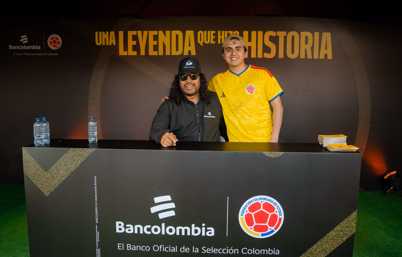 René Higuita posa con un aficionado en la mesa de firmas de Bancolombia