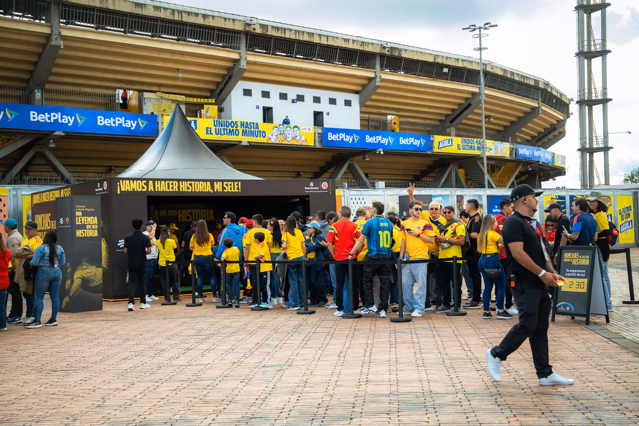 Aficionados con la camiseta de la Selección hacen fila frente al stand junto al estadio