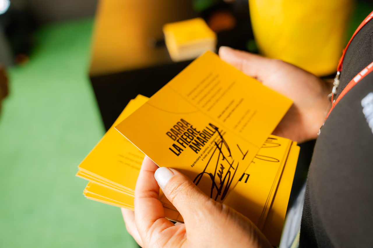 Manos sostienen tarjetas autografiadas entregadas durante la activación