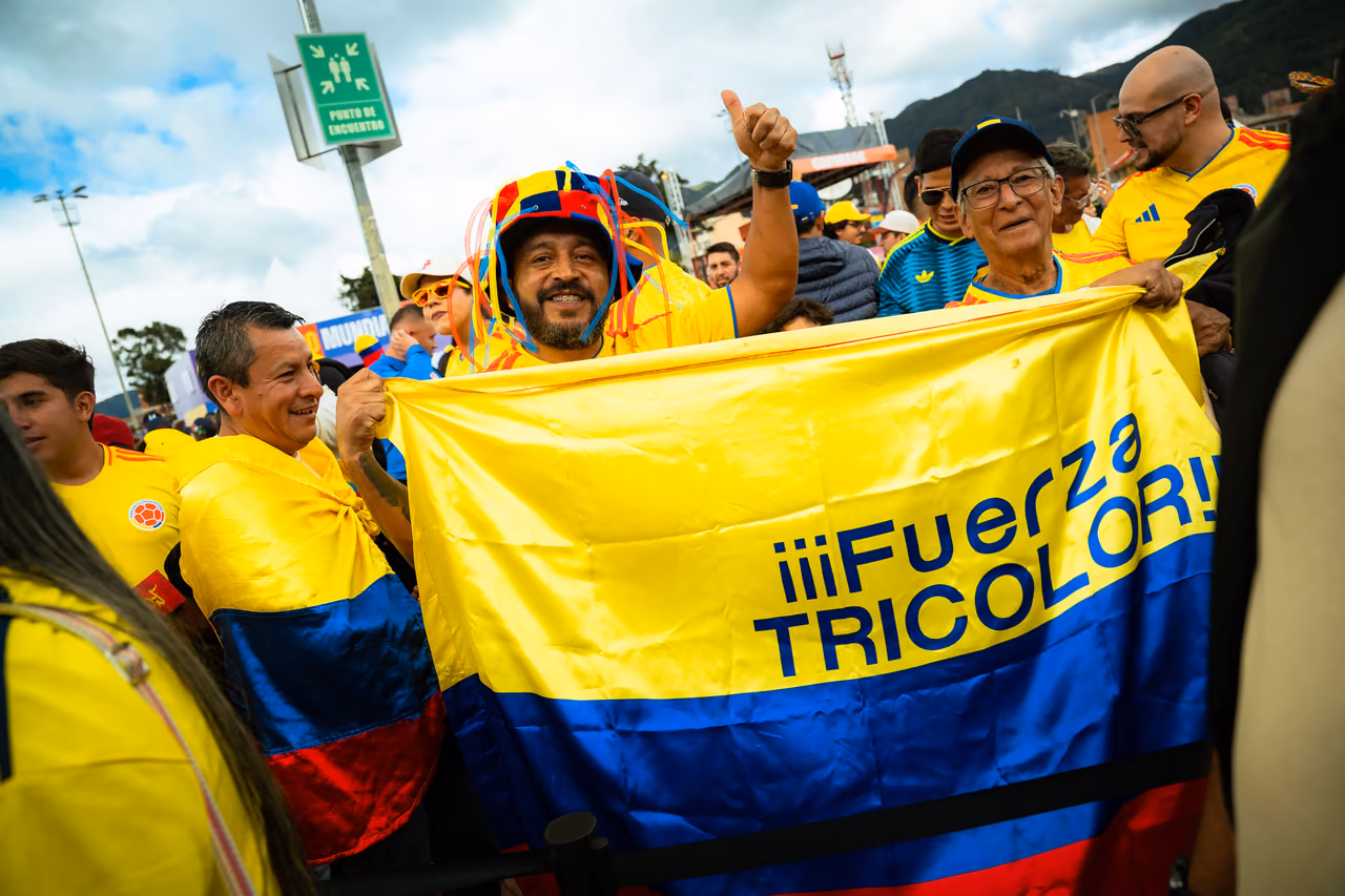 Aficionados extienden una bandera de Colombia con el lema «Fuerza tricolor»