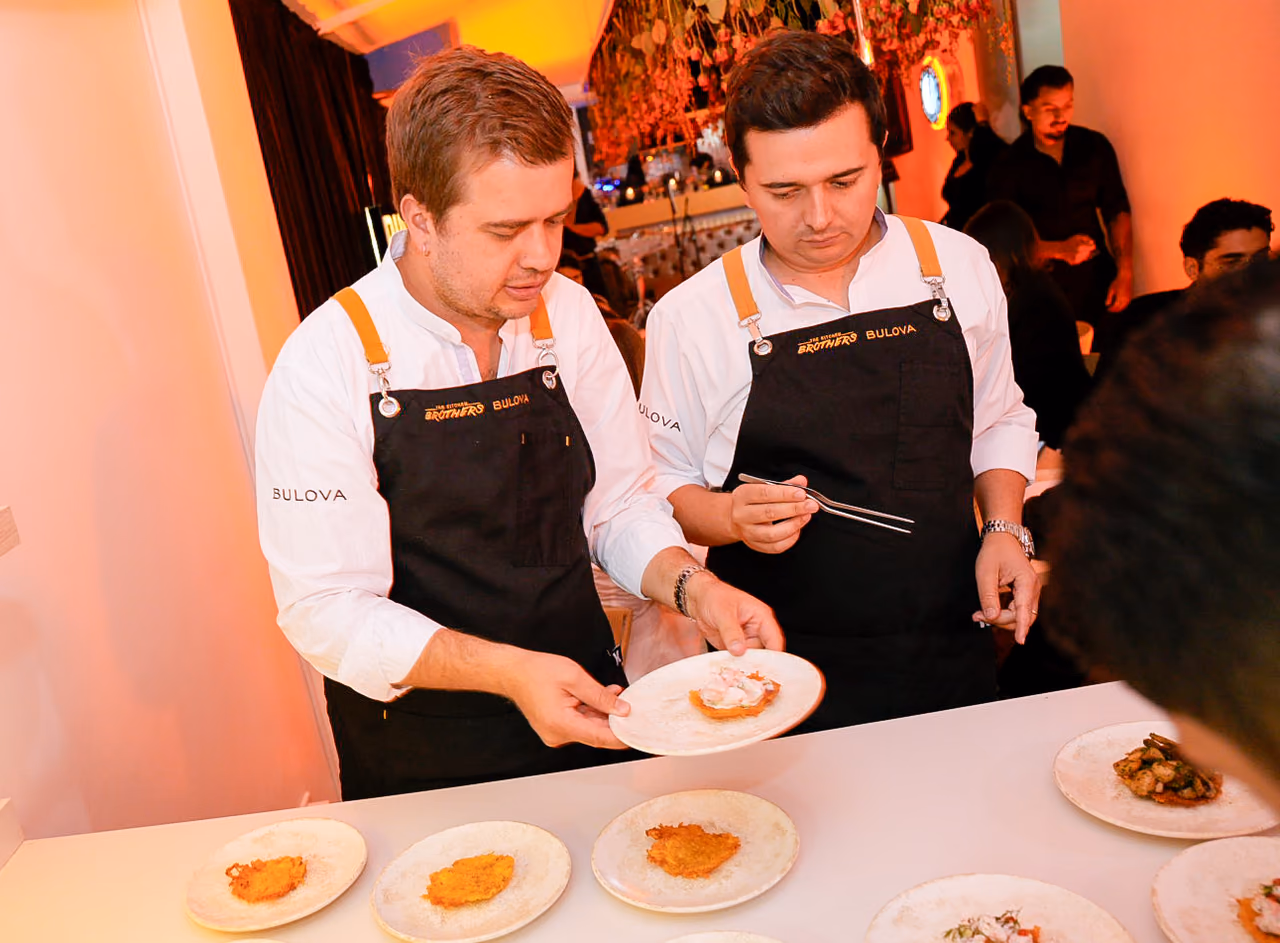 Dos chefs emplatan frente a los invitados durante la cena