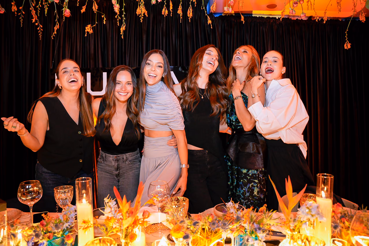 Grupo de invitadas celebra frente a la mesa principal