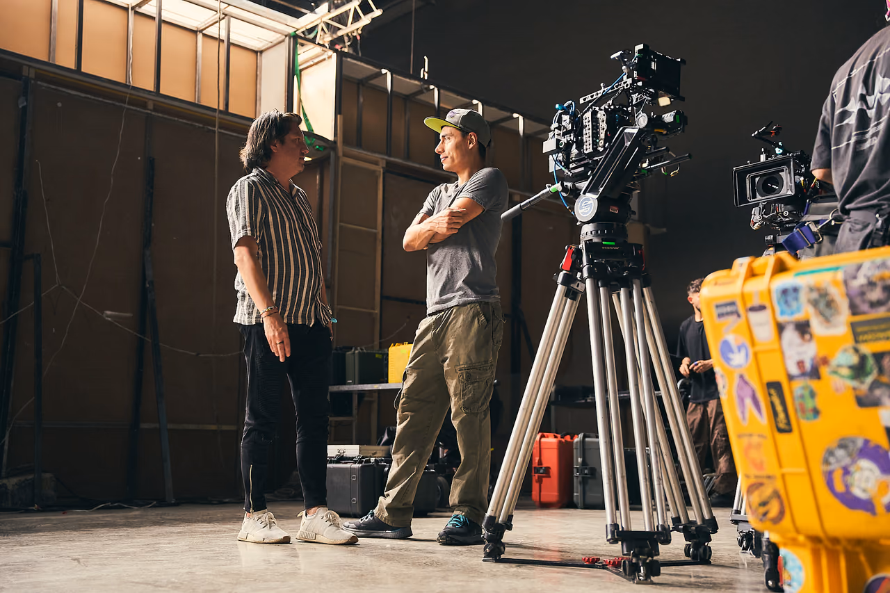 Director de fotografía y operador junto a una cámara de cine en el set