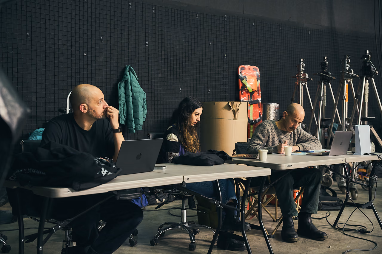 Equipo de producción trabaja en sus portátiles junto al set
