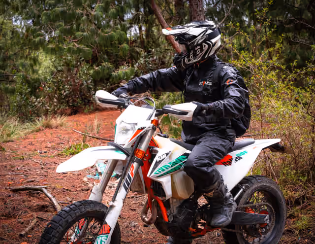Motociclista en movimiento sobre un sendero de bosque