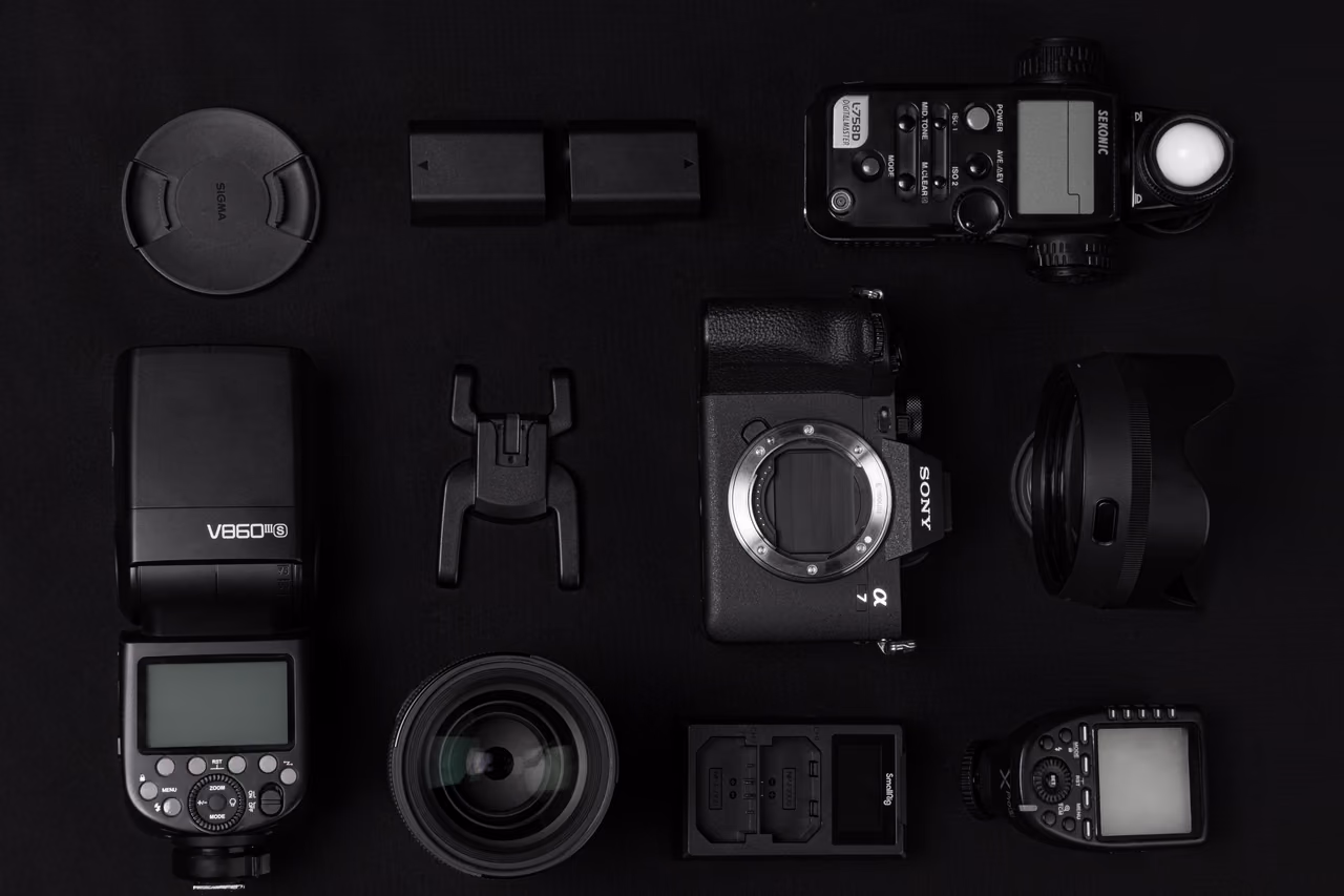 Cámara, objetivos, flashes y accesorios de Sequoia Studio ordenados sobre fondo negro