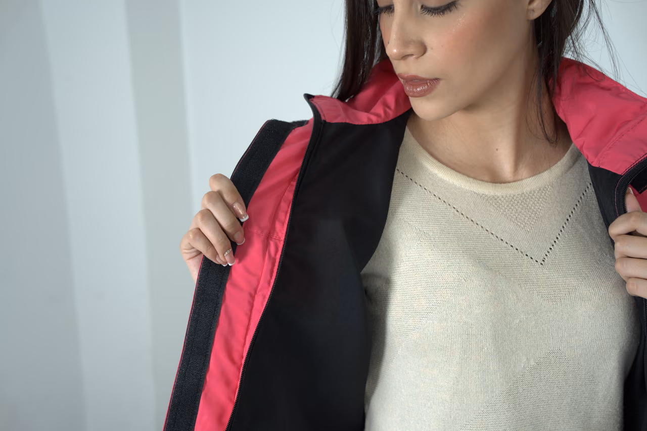 Detalle del forro rosado de una chaqueta negra sobre una modelo