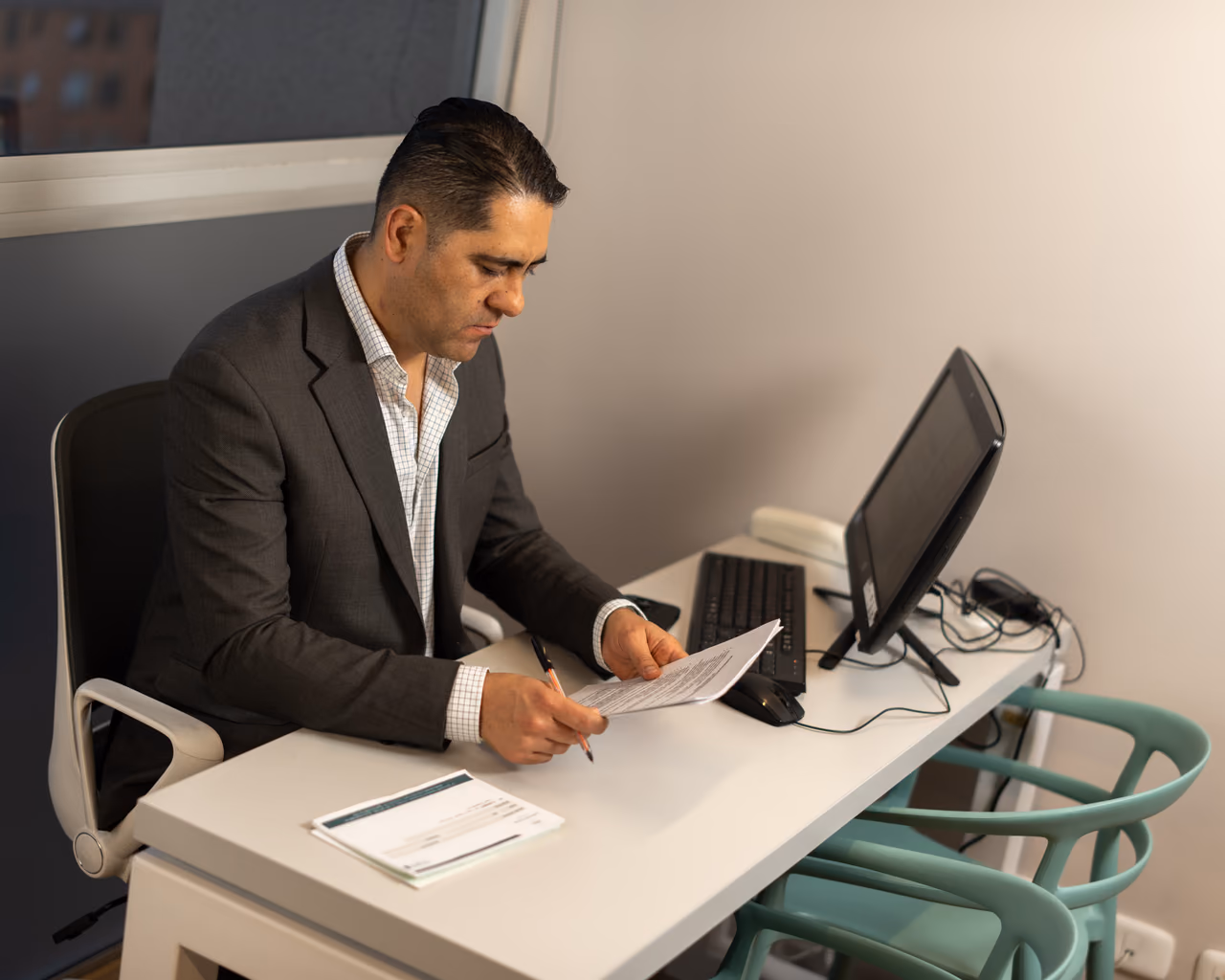 Retrato corporativo de un profesional revisando documentos en su escritorio de oficina