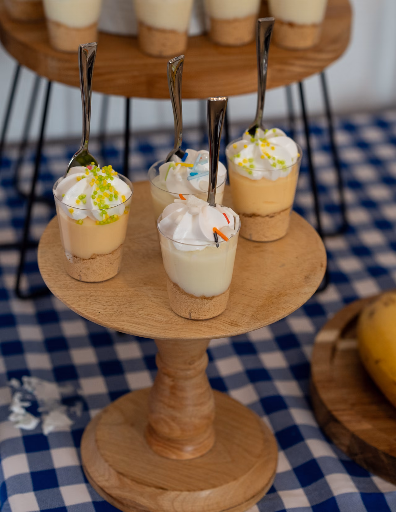 Postres individuales con crema y flores sobre soportes de madera