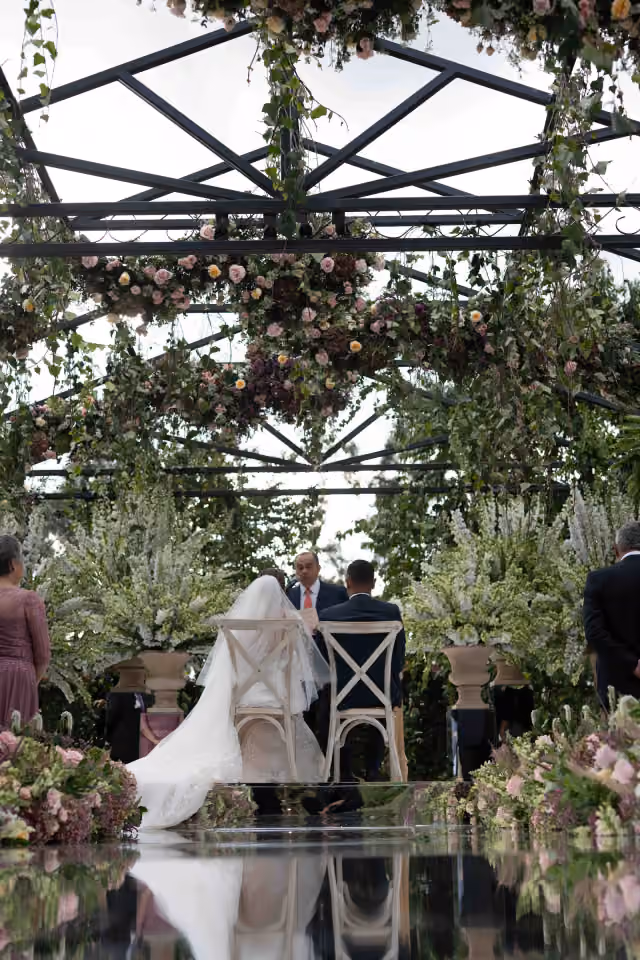 Ceremonia de boda en un jardín vista a través de un espejo