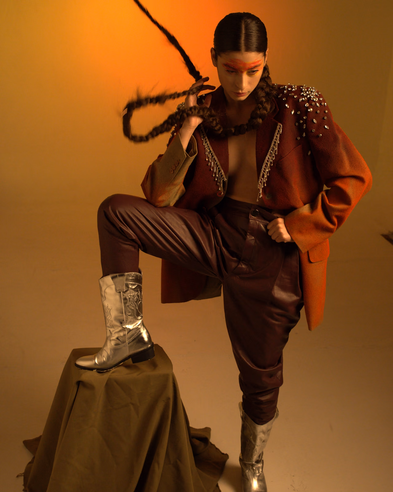 Modelo con chaqueta bordada en un estudio de luz ámbar